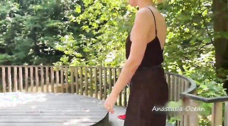 The girl topless is walking in the park in public