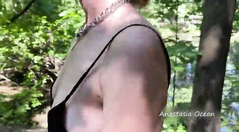 The girl topless is walking in the park in public